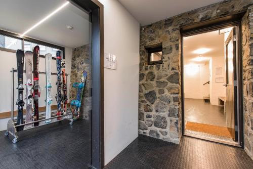 um quarto com esquis e snowboards numa parede em Boali Lodge Thredbo em Thredbo