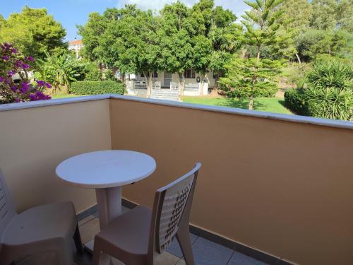 a balcony with a table and chairs and trees at Elanthi Village Apartments in Kalamaki