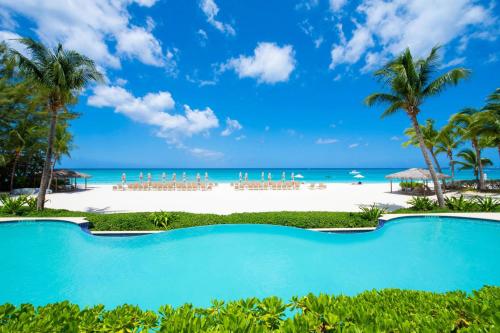 a swimming pool in front of the beach at Beachcomber 03 in George Town