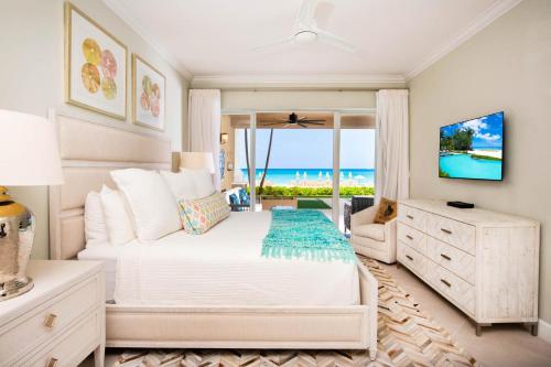 a bedroom with a bed and a view of the ocean at Beachcomber 03 in George Town