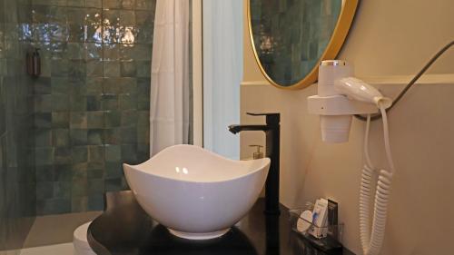 a bathroom with a white bowl sink and a shower at Hotel Monasterio San Pedro in Cusco