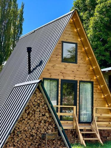 a log cabin with a metal roof and windows at Mestia Sunrise Cottage, 1BR Mountain Stay Svaneti in Mestia
