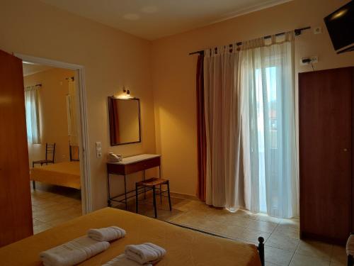 a hotel room with a bed and a mirror at Elanthi Village Apartments in Kalamaki