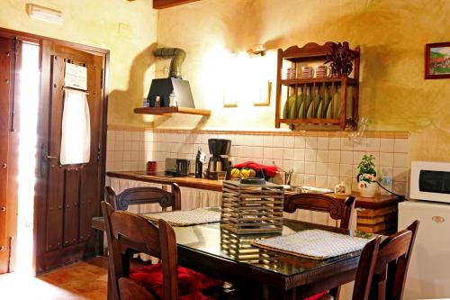 a kitchen with a table and some chairs and a counter at Apartamentos Rurales La Solana in Robledillo de Gata