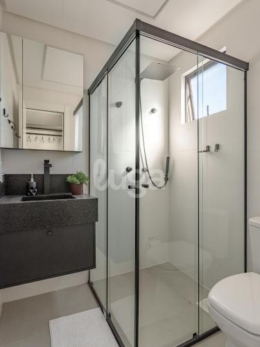a bathroom with a glass shower and a toilet at Comfort & Leisure – Oasis in Itapema in Itapema