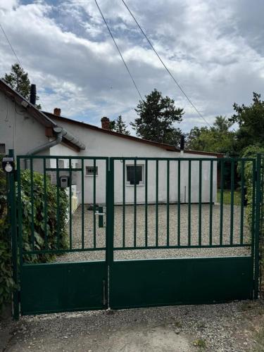 a green gate in front of a house at Juicy Private Apartments with Jacuzzi in Szentendre