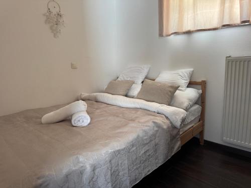 a bed with white sheets and pillows on it at Juicy Private Apartments with Jacuzzi in Szentendre