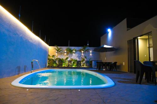 a swimming pool in the middle of a patio at night at Flat Brasil Piscina e Conforto in Olímpia