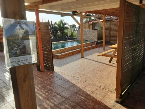 an open door to a patio with a swimming pool at Gîtes La Troisième Chute in Capesterre-Belle-Eau