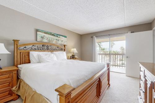 een slaapkamer met een groot bed en een balkon bij Marlin Arms Condominiums #9 in South Padre Island