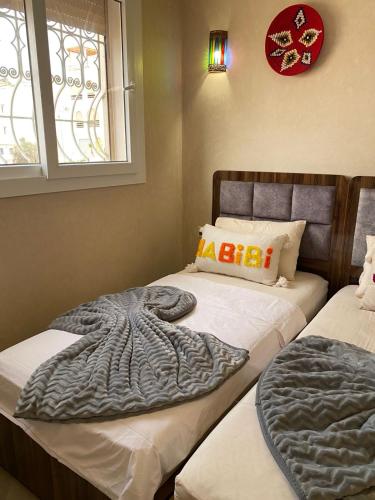 a bedroom with two beds with a blanket on them at taghoba surf house in Tamraght Ouzdar