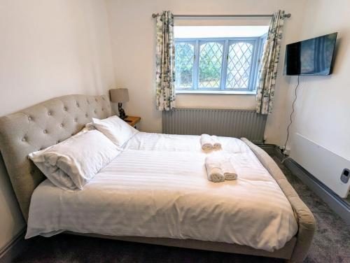 Un dormitorio con una cama con dos pantuflas encima. en Private Ensuite Room, en Nantwich