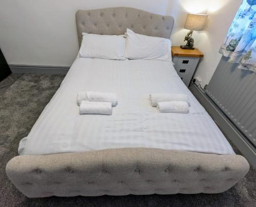Una cama blanca grande con dos toallas encima. en Private Ensuite Room, en Nantwich