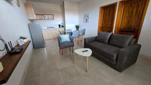 a living room with a couch and a table at CASA BLANCA HORTENCIA in Sucúa