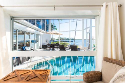 a view from the living room of a house with a pool at Pools of the Kai 6 - Beachfront Condo with Private Pool Atrium, Modern Kitchen, and Outdoor Grill in Driftwood Village
