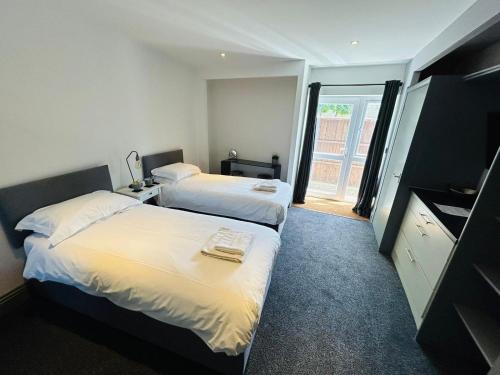 a hotel room with two beds and a window at Wessex House in Basingstoke