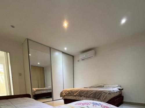 a bedroom with two beds and a mirror at Hermosa Casa Alquiler Temporario in Corrientes