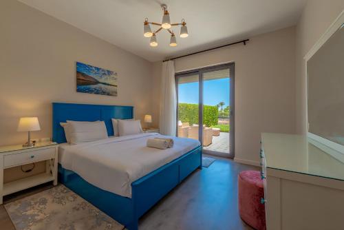 a bedroom with a blue bed and a large window at Luxury Stays in Cyan El Gouna in Hurghada