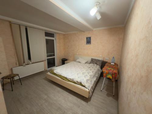a bedroom with a bed and a table in it at Simple and accessible in Durleşti