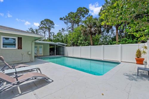 una piscina con dos sillas y una valla en Luxury Getaway In Naples Pool Elegant Remodel, en Naples
