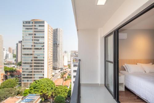 a bedroom with a bed and a view of a city at Perdizes Smart Experience - Ao lado do Allianz Parque in Sao Paulo