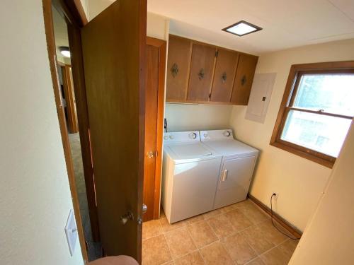 una pequeña cocina con lavadora y secadora. en Alaskana - Walk to Downtown, 3 Bedroom Upper Apt, en Slaterville