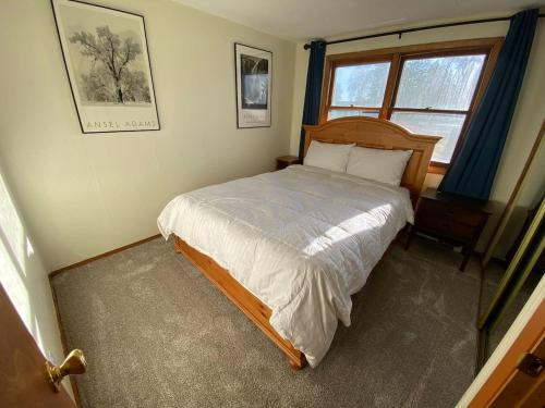 un dormitorio con una cama y una ventana en Alaskana - Walk to Downtown, 3 Bedroom Upper Apt, en Slaterville