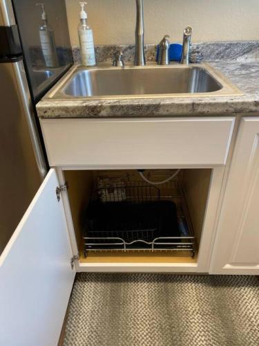 a kitchen sink with a dish rack under it at Coffee studio, walking distance to downtown in Fairbanks
