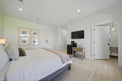 Un dormitorio blanco con una cama grande y un escritorio. en Sanitella Suite, en Walla Walla