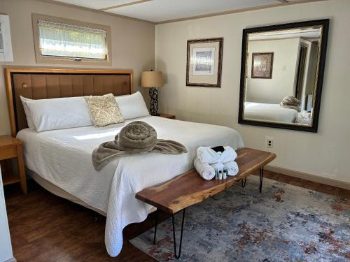 a bedroom with a bed with a table and a mirror at Starlight Lodge at Rockport Harbor in Rockport