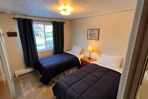 Una pequeña habitación con dos camas y una ventana. en Wild Alaskan 3 Bd Upper Apt Close to downtown, en Slaterville