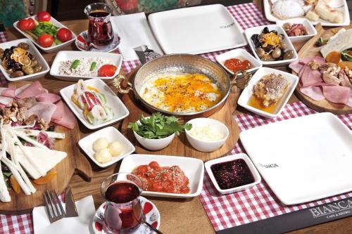 a table with many different dishes of food on it at Casa Bianca Hotel in Denizli