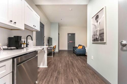 eine Küche mit weißen Schränken und ein Wohnzimmer in der Unterkunft Accessible Comfort Near Atrium & Downtown Macon in Macon