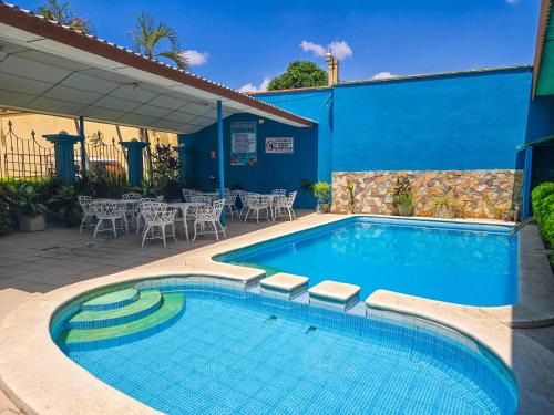 a swimming pool with tables and chairs next to a building at Hotel Continental Plaza in San Miguel