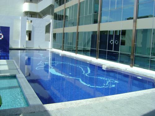 a large swimming pool in front of a building at New Season Square Hotel in Hat Yai