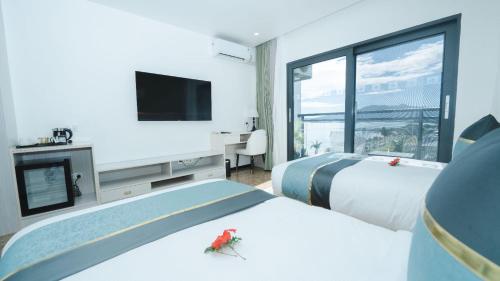 una camera d'albergo con due letti e una televisione di Wyndham Garden Wailoaloa Beach Fiji a Nadi