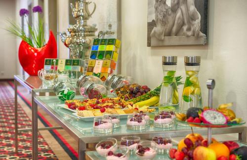 a buffet of fruits and vegetables on a table at Leonardo Hotel Karlsruhe in Karlsruhe