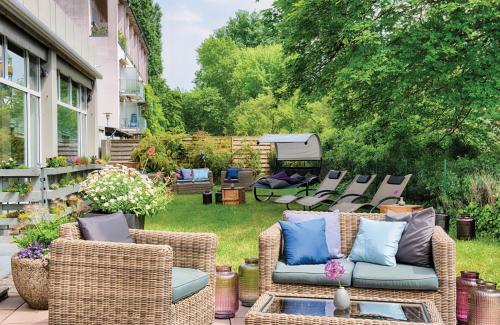 a patio with wicker chairs and a table at Leonardo Hotel Karlsruhe in Karlsruhe