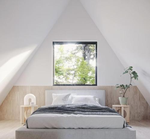 a white bedroom with a bed and a window at A-FRAME Ξυλόκαστρο 