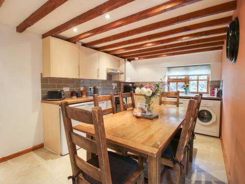 a kitchen with a wooden dining room table with chairs at Old Hall Barn 4 in Church Stretton
