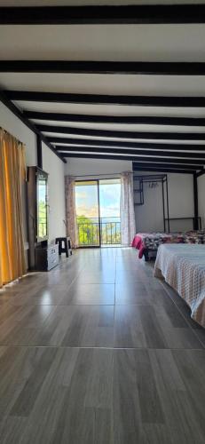 バルボサにあるCasa Campestre Taraのベッド1台、大きな窓が備わる広い客室です。