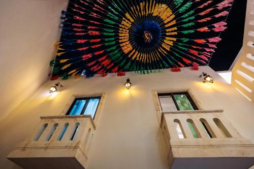 a large painting on the ceiling of a building with two windows at Casa Margarito Jalatlaco in Oaxaca City