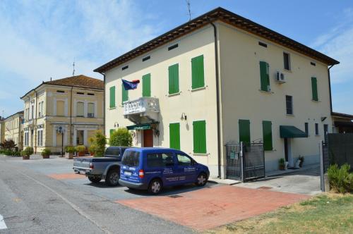 Motteggiana的住宿－B&B Cambusa，停在绿色百叶窗建筑前的蓝色汽车