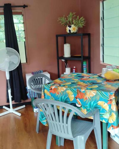 a dining room with a table and two chairs at Faatiarau Bed in Fare