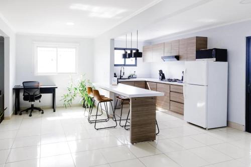 a kitchen with a white refrigerator and a table and chairs at New Modern 3br Private Pool, 6min Form The Beach in Wayaca