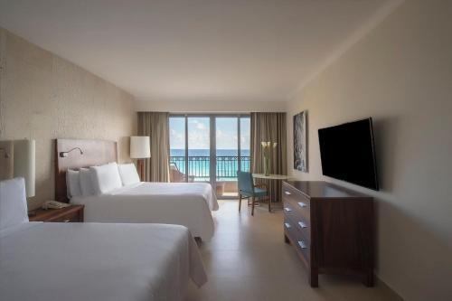 a hotel room with two beds and a flat screen tv at Fiesta Americana Condesa Cancun - All Inclusive in Cancún