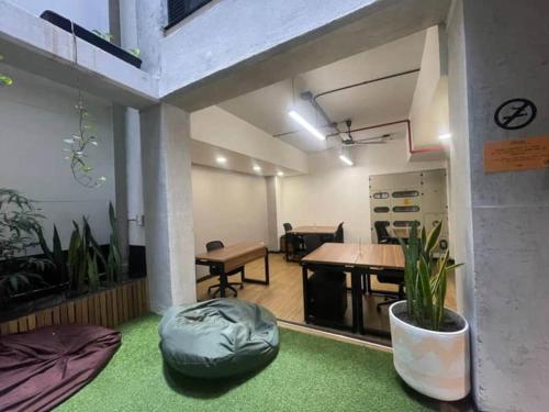 Una habitación grande con una mesa y una habitación con plantas. en Dormitorios en Medellín con áreas comunes, Coworking - Be Together by Roots Rentals TOG HAB, en Medellín