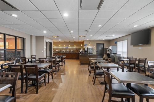 a restaurant with tables and chairs and a kitchen at Best Western Blairmore in Saskatoon