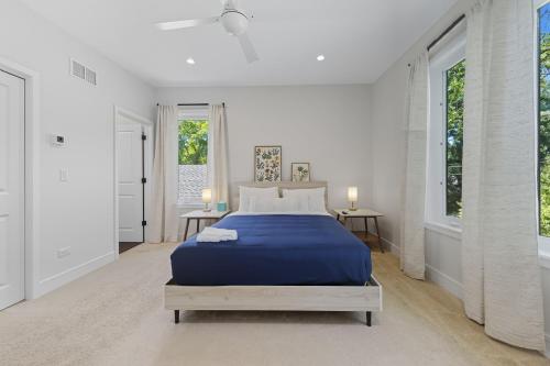 WilmetteにあるBright Modern 3Bed 2,5Bath Evanston Home withParking homeの白いベッドルーム(青いベッド1台、窓2つ付)
