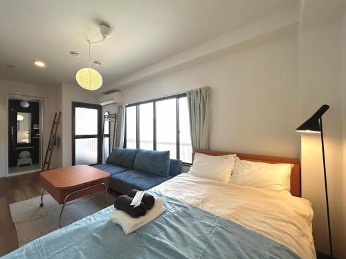 ein Schlafzimmer mit einem Bett und einer Couch in der Unterkunft トライアングル若宮201 trianglewakamiya in Tokio